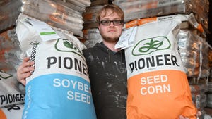  Ryan Lynch, Francesville, Indiana holds soybean seed and corn seed bags